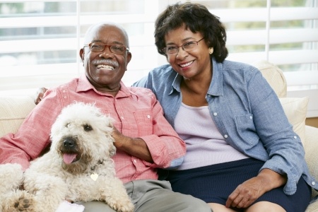 a couple sitting on their couch with their dog