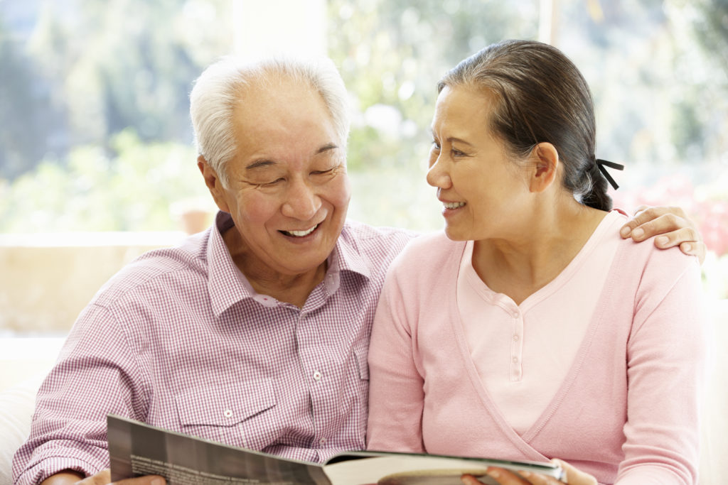 Senior Asian couple reading magazine