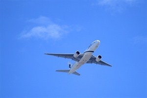 an airplane flying under a blue sky