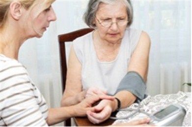 A senior adult female has her blood pressure checked