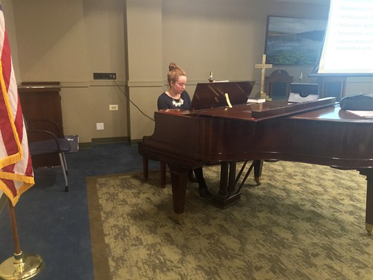 A woman plays a piano