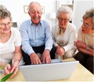 a group of senior adults look at a laptop