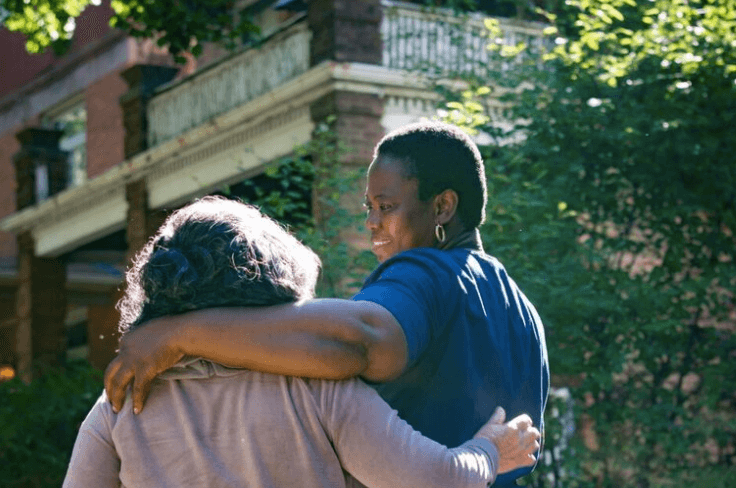 Two women with arms around each other discuss mental health screening