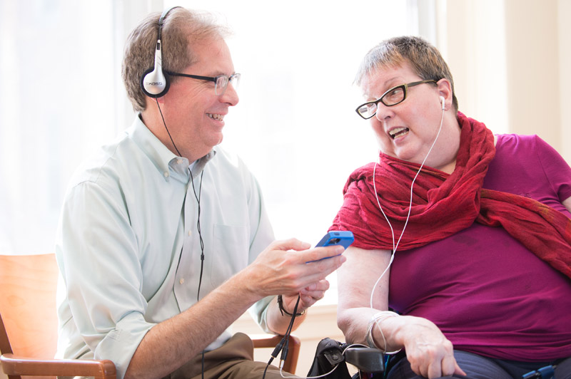 A woman listens to music on her headphones as part of a music therapy memory program