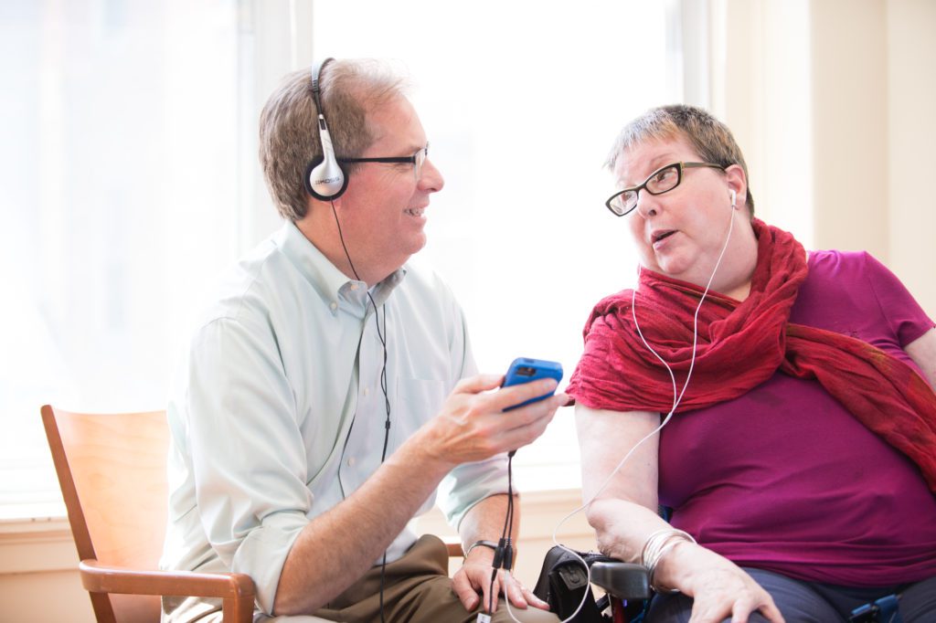 A woman listens to music on her headphones as part of a music therapy memory program