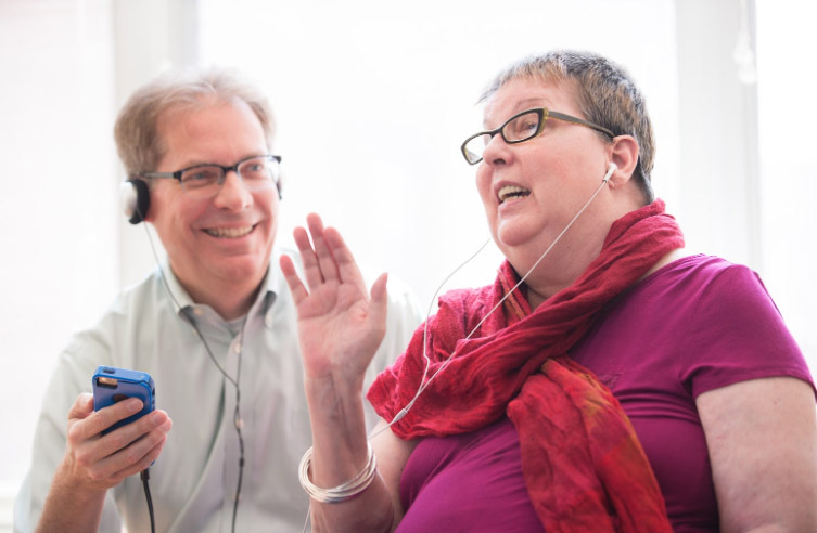 A woman listens to music on her headphones as part of a music therapy memory program