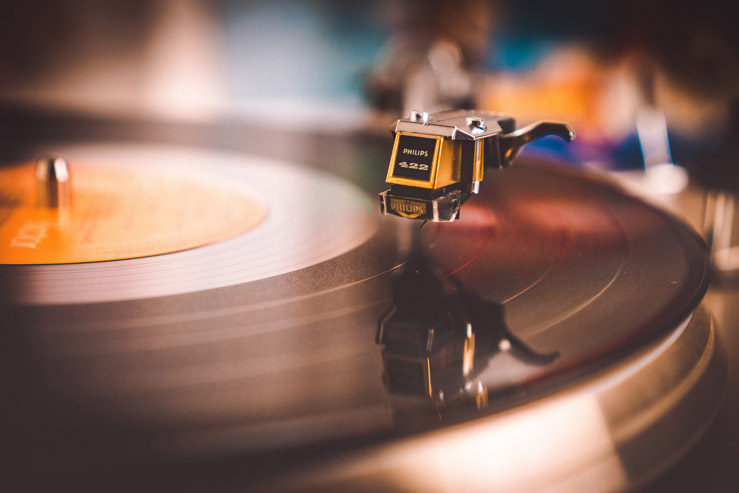 A closeup of a record player needle dropping onto a spinning record