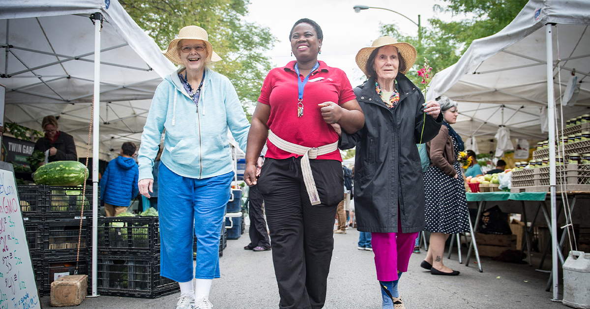 Senior women walking through a market with a healthcare provider.