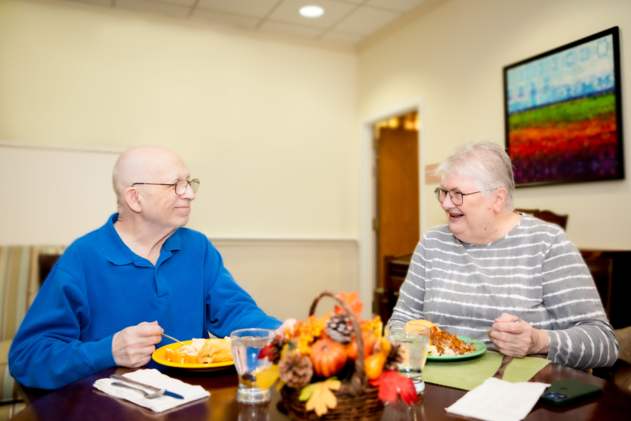 Image of two white seniors eating across from each other.