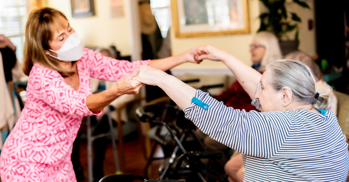 Image of volunteer dancing with elderly senior resident.