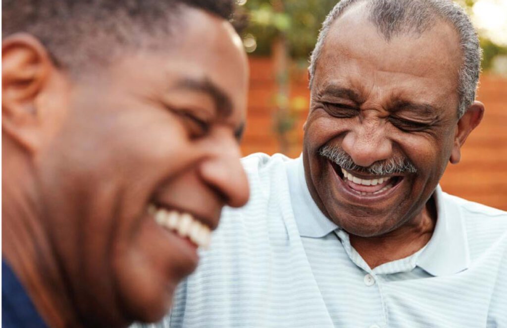 Image of older man and younger man laughing.