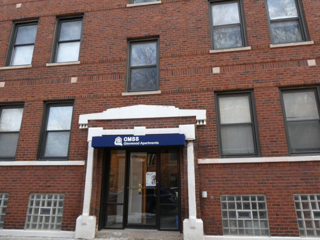 A brown brick building with a blue awning.