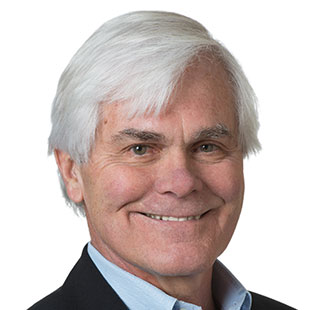 A portrait photo of a man with hair wearing a black suit.