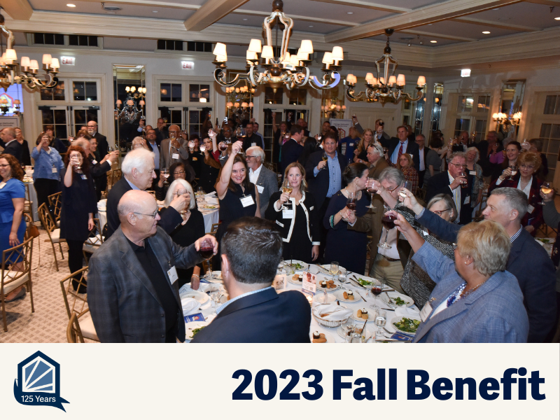 Ballroom of people standing and raising a glass for a toast.