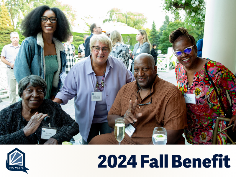Five people are seated on a beautiful balcony smiling for the camera.