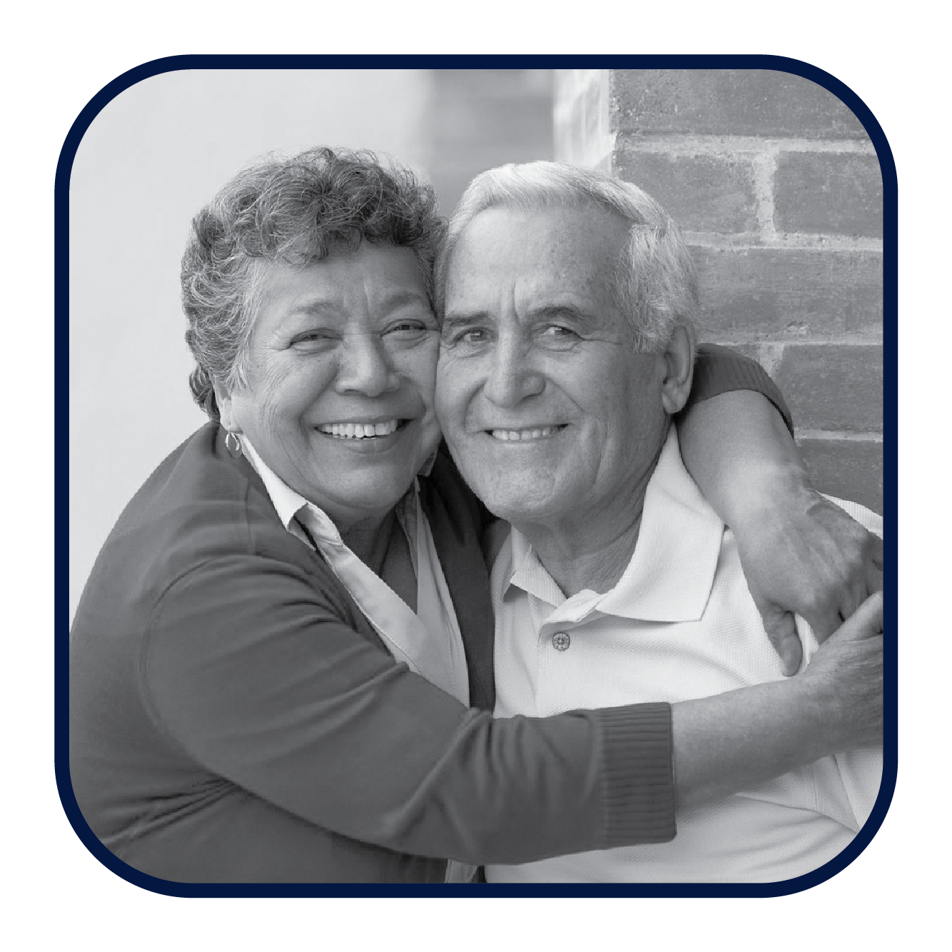 A Latino couple smiles for the camera, the woman's arms are around the man's neck.