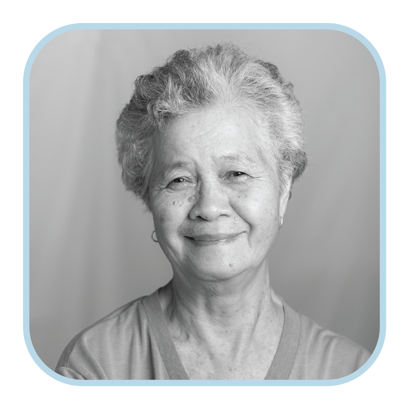 An older Asian woman with short hair smiles at the camera.