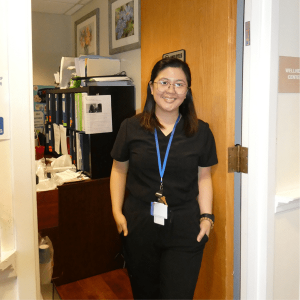 A woman nurse stands in the nurses office at Hartwell Place.