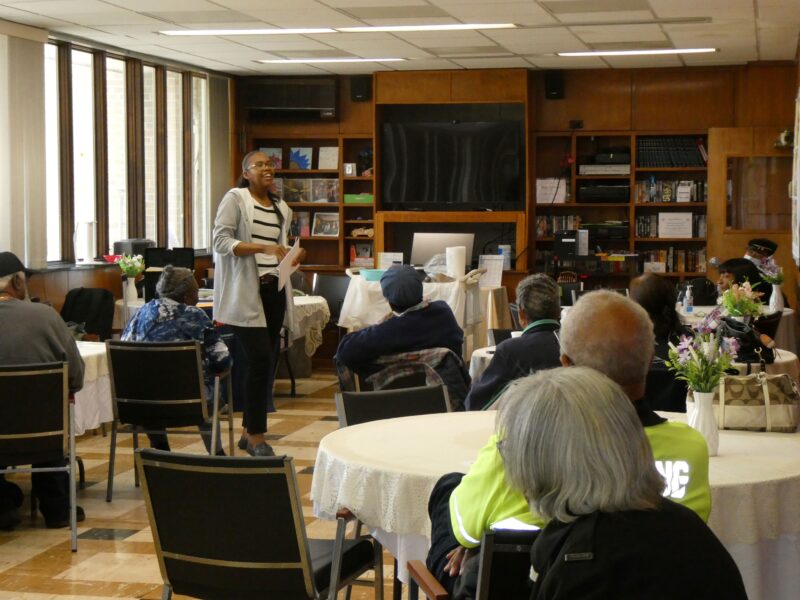 A woman presents to a room of older adults.